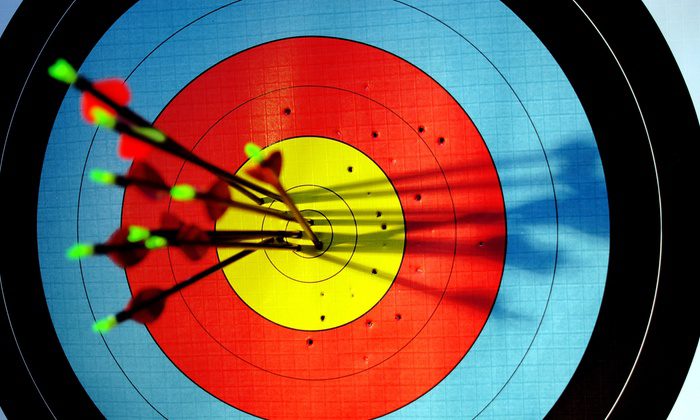 A close up of an archery target with arrows in it
